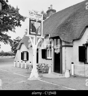 1950er Jahre, Olde English Public House oder inn, The Cat & Fiddle at Hinton Admiral, Hampshire, England, Großbritannien, mit Schild und traditionellem Strohdach. Stockfoto