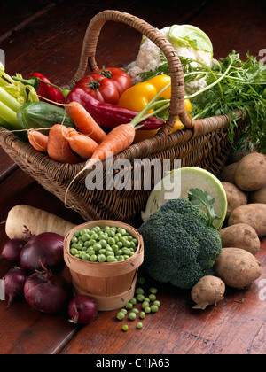 Wicker Korb rohes Gemüse Tomaten süß rot gelb Paprika Karotten Erbsen Blumenkohl Pastinaken Brokkoli kochen Zutaten Stockfoto