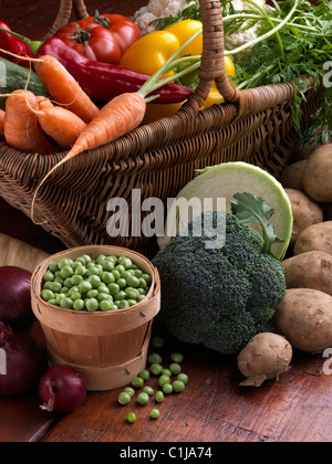 Wicker Korb rohes Gemüse Tomaten süß rot gelb Paprika Karotten Erbsen Blumenkohl Pastinaken Brokkoli kochen Zutaten Stockfoto