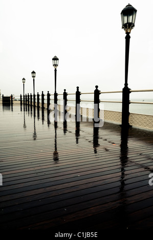 Eine Periode Laternen reflektiert auf dem Art-Deco-Worthing Pier an einem regnerischen Frühling Nachmittag. Stockfoto