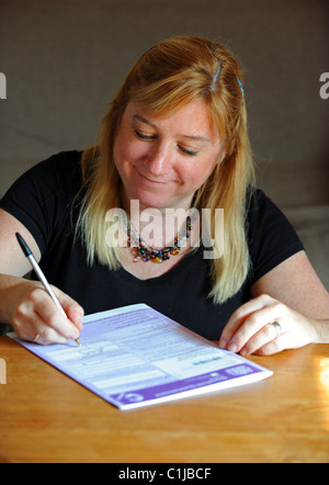 Eine Frau Ausfüllen des Zensus-Formulars UK 2011 zu Hause Stockfoto