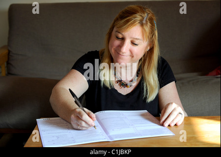 Eine Frau Ausfüllen des Zensus-Formulars UK 2011 zu Hause Stockfoto