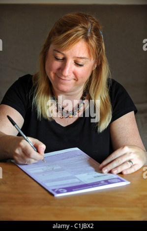 Eine Frau Ausfüllen des Zensus-Formulars UK 2011 zu Hause Stockfoto