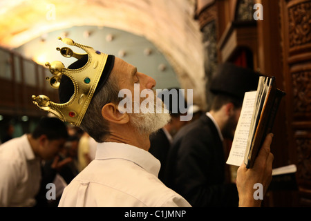 Ein ultra-orthodoxer Jude trägt ein königliches Königskostüm, als er während des jüdischen Purim-Festivals in der alten Stadt Ostjerusalem Israel das Megillah (Buch der Esther) liest Stockfoto