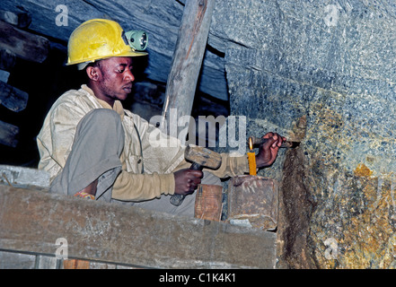 Ein unterirdische Arbeiter erzeugt ein Loch für Sprengstoff bei der Suche nach wertvollen Erzen in einer Goldmine in Johannesburg, Südafrika. Stockfoto