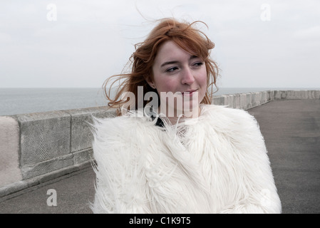 Frau auf Margate Hafenmauer an einem windigen Tag Stockfoto