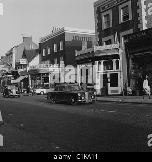 Die historischen, eleganten Autos der Ära der 1969er reisen entlang der berühmten Kings Road in Chelsea, London, England, vorbei an dem berühmten Pub, dem Chelsea Potter. Stockfoto