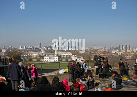 Kinder auf einer Reise nach Greenwich Park, London, England, Blick über Teile der Stadt, darunter The Queens House und Canary Wharf Stockfoto