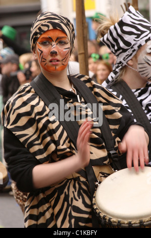 Mädchen spielen Haut drum mit bemaltem Gesicht in Cork St Patrick's Day Parade Tier Stockfoto