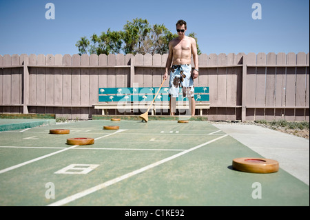 Mann spielen Shuffleboard in Yuma County Trailer Park, Yuma, Arizona, USA Stockfoto