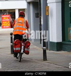 Postbote mit dem Fahrrad mit Gepäcktaschen auf seiner Stadt Zentrum Runde in Evesham England UK Stockfoto