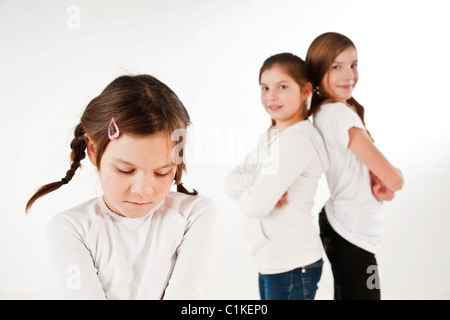 Kleines Mädchen sucht verärgert, zwei Mädchen im Hintergrund Stockfoto