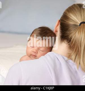 Baby schläft auf Mutters Schulter Stockfoto