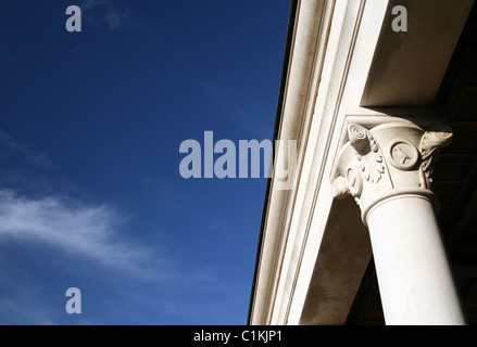 Fragmentneoclassical Kalkstein, glatte, zylindrische Säulen und blauer Himmel mit einer Nahaufnahme einer Cloud. Kirche in Pula, Kroatien Stockfoto