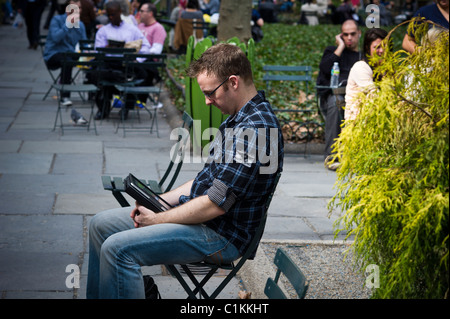 Ein Leser nutzt seine Apple iPad im Bryant Park in New York während der Mittagszeit geöffnet Stockfoto