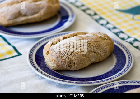 Ansicht von drei frische, gebackene Brote kleine Brote innerhalb drei Platten auf einem Tisch. Stockfoto