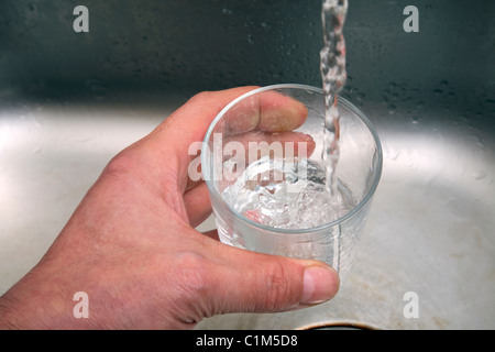 Man füllt ein Glas mit Wasser aus einem Wasserhahn Küche. Stockfoto