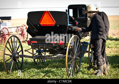 Junge Amish-Männer inspizieren einen Pferd Buggy während des jährlichen Schlamm Verkaufs zur Unterstützung der Feuerwehr in Gordonville, PA. Stockfoto