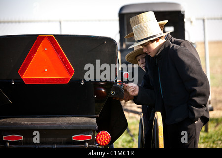 Junge Amish-Männer inspizieren einen Pferd Buggy während des jährlichen Schlamm Verkaufs zur Unterstützung der Feuerwehr in Gordonville, PA. Stockfoto