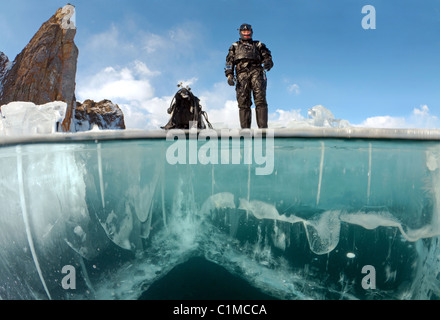 Unterwasser auf 2 Ebenen, weiblichen Scuba diver Vorbereitung auf Eis - Tauchen im Baikalsee, Sibirien, Russland, Insel Olchon. Stockfoto