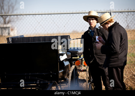 Junge Amish-Männer inspizieren einen Pferd Buggy während des jährlichen Schlamm Verkaufs zur Unterstützung der Feuerwehr in Gordonville, PA. Stockfoto