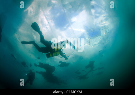 Scuba Diver in sidemount Schwimmen unter Eis Eis-Tauchen im Baikalsee, Sibirien, Russland, Insel Olchon. Stockfoto