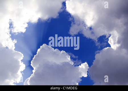 Strahlen von Sonne im blauen Himmel graue Wolken Skyscape Hintergrund Stockfoto