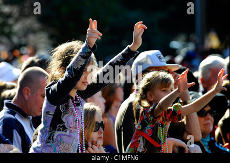 Junges Mädchen wirft Hände und Arme in Menge während Gasparilla Piraten Festival Parade Tampa Florida Stockfoto