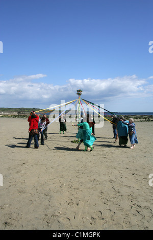 Tanz um den Maibaum. Eine alte heidnische Fruchtbarkeit Feier am Strand vor St. Michaels Mount durchgeführt wird. Stockfoto