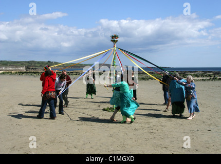 Tanz um den Maibaum. Eine alte heidnische Fruchtbarkeit Feier am Strand vor St. Michaels Mount durchgeführt wird. Stockfoto