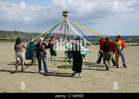 Tanz um den Maibaum. Eine alte heidnische Fruchtbarkeit Feier am Strand vor St. Michaels Mount durchgeführt wird. Stockfoto