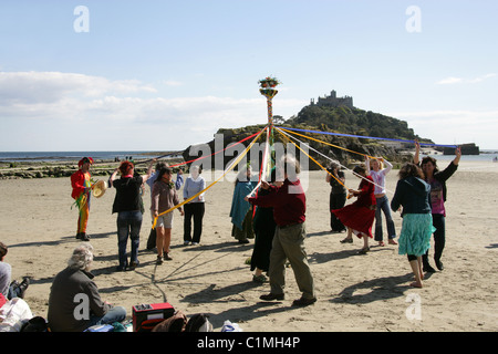 Tanz um den Maibaum. Eine alte heidnische Fruchtbarkeit Feier am Strand vor St. Michaels Mount durchgeführt wird. Stockfoto