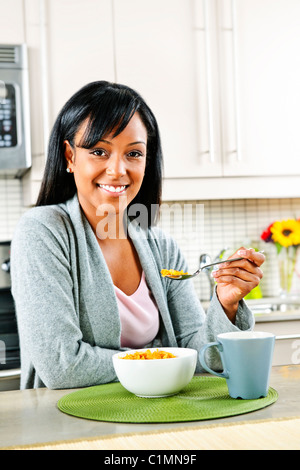 Lächelnde schwarze Frau mit Frühstück im modernen Küche Interieur Stockfoto