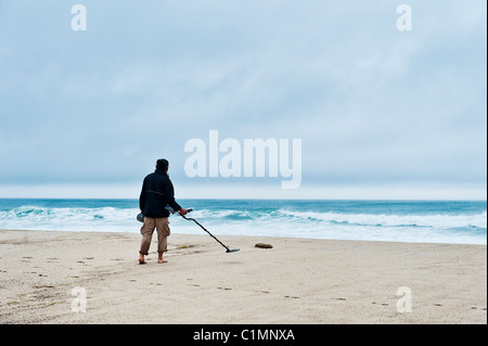 Mann Suche Strand mit einem Metalldetektor. Stockfoto