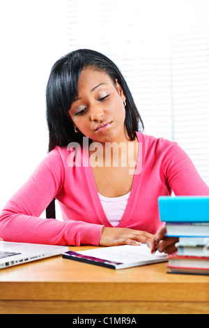 Junge schwarze Studentin Studium am Schreibtisch schauen traurig Stockfoto