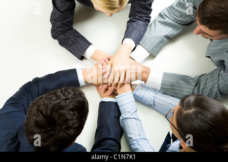 Konzeptionelle Darstellung der Menschen halten Hände übereinander Stockfoto