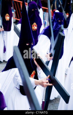 Mitglied der katholischen Kirche Teilnahme / Verarbeitung mit einem Kreuz / Kruzifix. Semana Santa Ostern Heiligen Woche Prozession. Sevilla Spanien Stockfoto