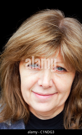 Porträt von schöne fröhliche mittlere gealterte Frau auf schwarzem Hintergrund Stockfoto