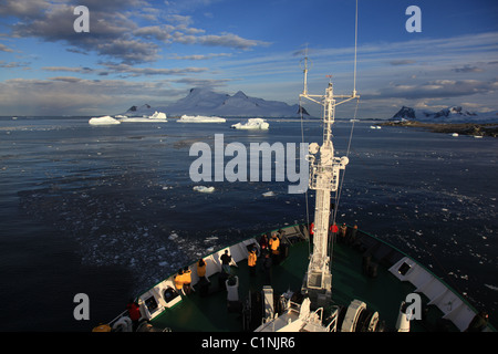 Land und sonnenbeschienenen Eisberge in [Marguerite Bay], [West Graham Land], Antarktis von polar Kreuzfahrtschiff abgewinkelt, Sonne und blauer Himmel Stockfoto