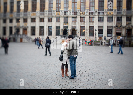 Paar stehen dicht beieinander, ein Foto auf ihrem Handy vor einer mittelalterlichen Gebäude auf der Grand Place zu sehen Stockfoto