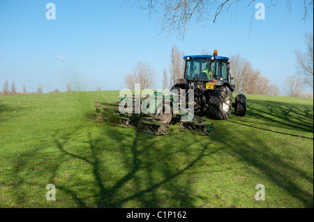 Ein Rat Traktor mäht den Rasen in einem öffentlichen Park. Stockfoto
