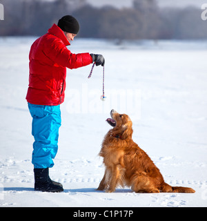 Junger Mann mit Hund im Freien spielen. Stockfoto