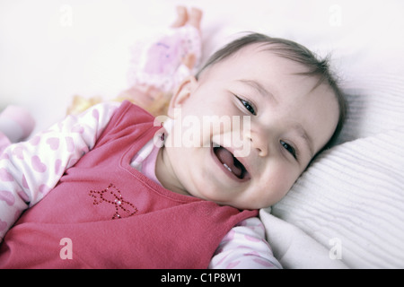 Glückliches Baby liegend auf dem Bett Stockfoto