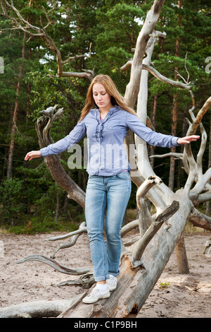 Frau balancieren auf umgestürzten Baum Stockfoto