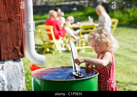 Mädchen spielen mit Spielzeugboot im Garten Stockfoto