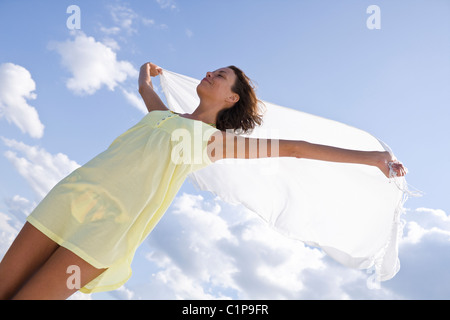 Junge Frau halten Schal gegen Himmel Stockfoto