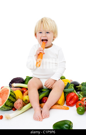 Studioaufnahme von Baby Boy umgeben von frischem Gemüse Stockfoto