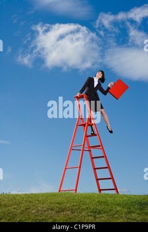 Geschäftsfrau mit roten Aktentasche stehen auf Leiter Stockfoto