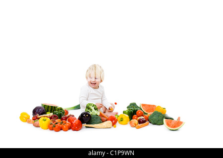 Studioaufnahme von Baby Boy umgeben von frischem Gemüse Stockfoto