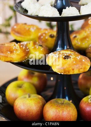 Äpfel und Safran Brötchen auf Cakestand, Nahaufnahme Stockfoto